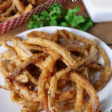 A white plate with Crispy Onion Strings on it.