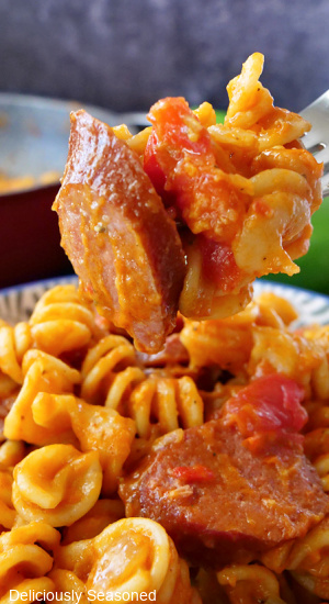 A bite of kielbasa sausage pasta on a fork.