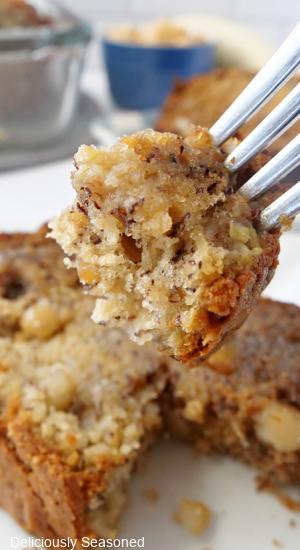 A bite of banana bread being held up on a fork.