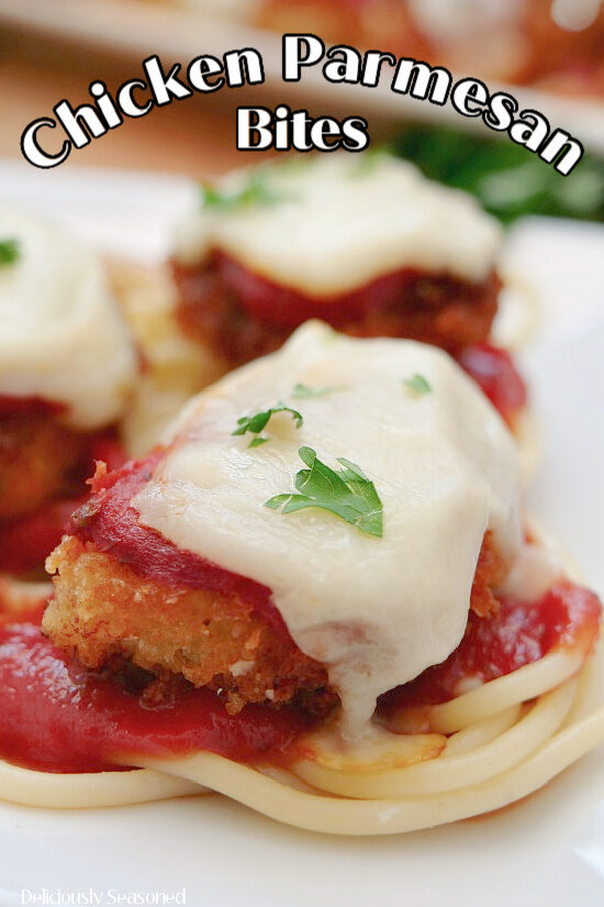 A close up of a chicken parmesan bite on some spaghetti pasta.
