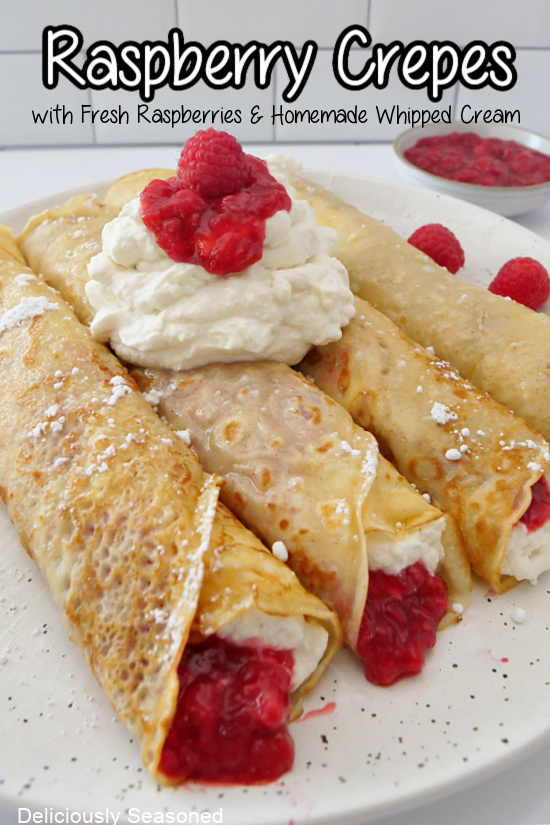 Four crepes filled with whipped cream and raspberry filling, all placed on a white plate.