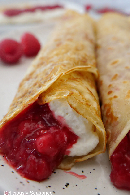 A close up photo of the inside ingredients of a raspberry crepe.