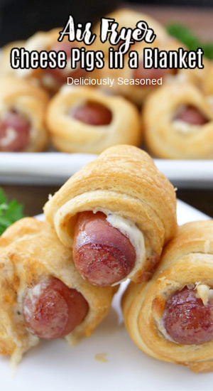 A pic of cheese pigs in a blanket stacked on top of each other on a white plate with the title at the top.