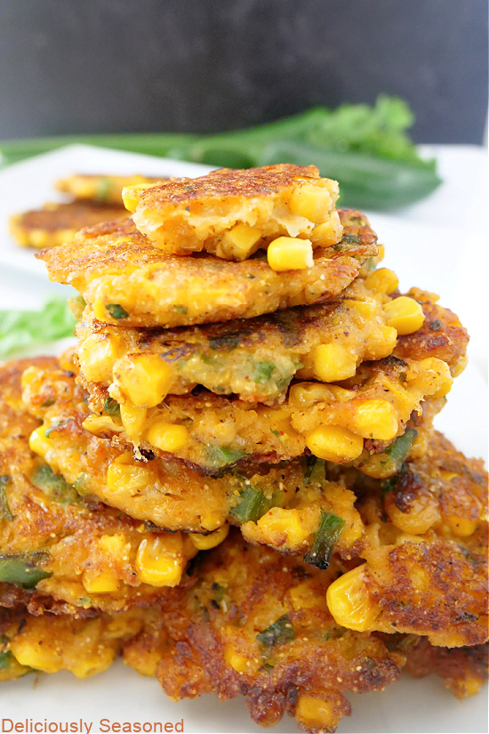 A giant stack of fritters on a big white plate.