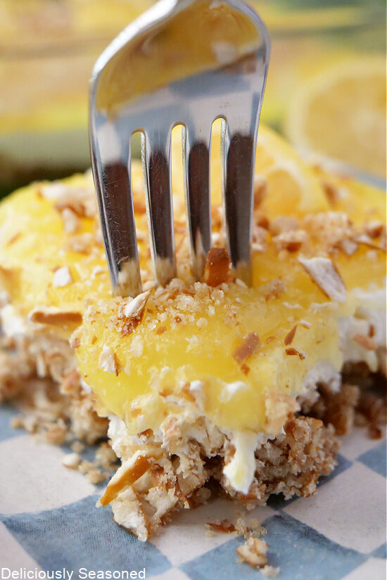 A close-up picture of lemon pretzel dessert with a fork inserted into it.