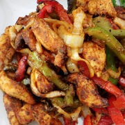 Air fryer chicken fajitas with strips of chicken, red pepper, green pepper, and onions.