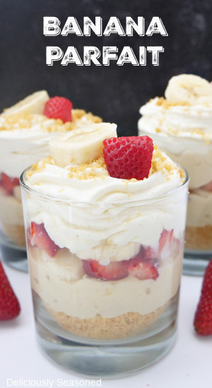 A title pic of three glass cups of banana parfaits topped with sliced banana and strawberries.