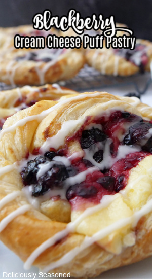 A blackberry cream cheese puff pastry on a white plate.