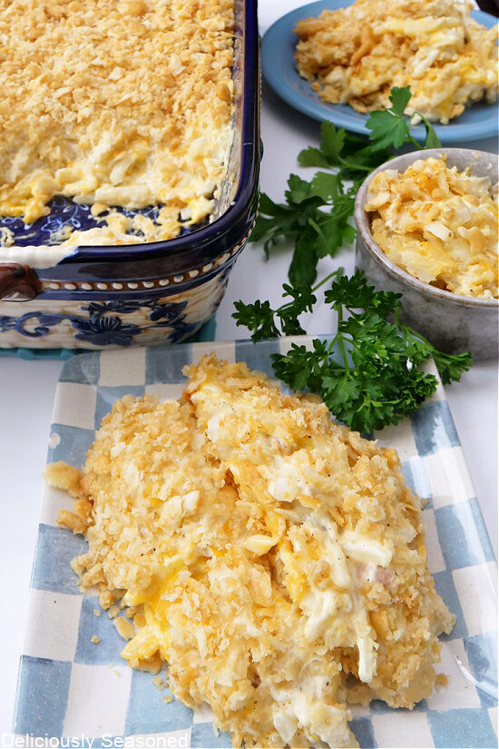 Cheesy potatoes on a light blue and white checkered square plate.