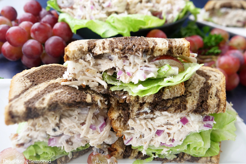 Three halves of chicken salad sandwiches stacked on top of one another.