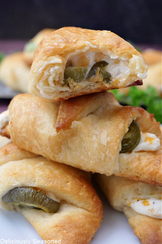 A stack of crescent rolls filled with cream cheese on a plate.