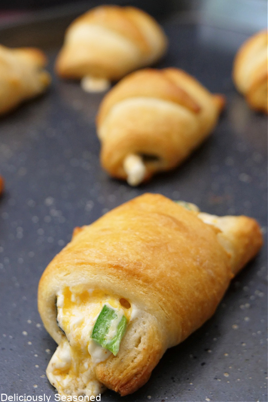 A cookie sheet with freshly baked stuffed crescent rolls.