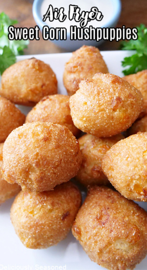 A stack of air fried corn hushpuppies on a white plate.