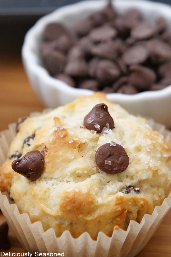 A close up photo of a chocolate chip muffin with coarse sugar on top.