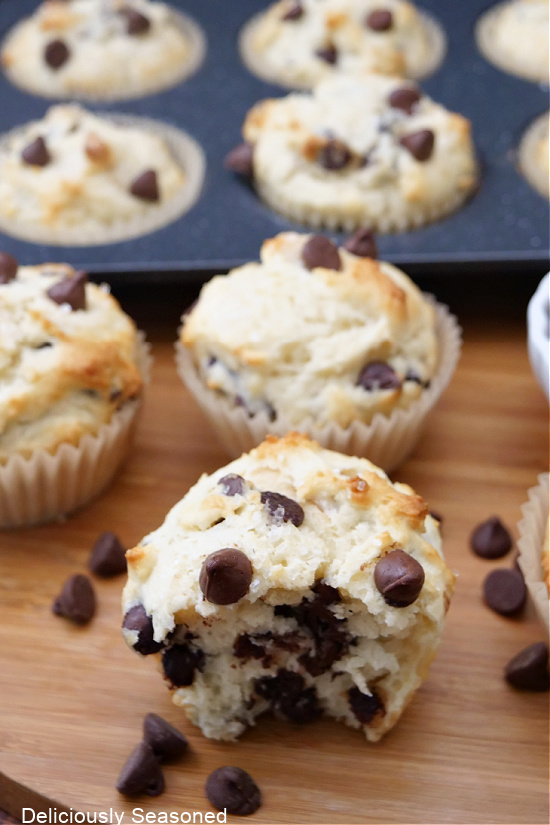A muffin pan in the background and a muffin sitting in the front.