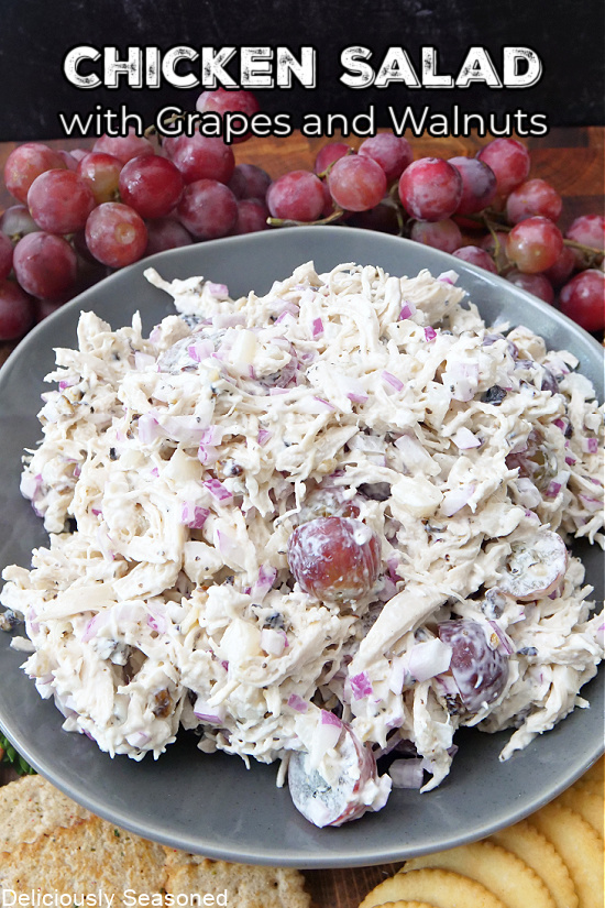 A big gray bowl full of chicken salad with walnuts and grapes.