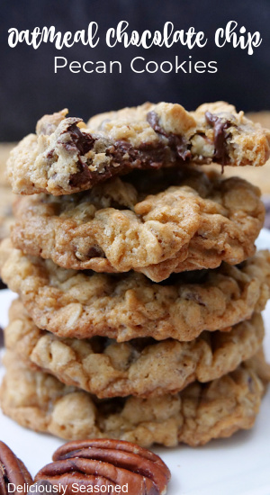 A stack of oatmeal chocolate chip cookies on a white plate.