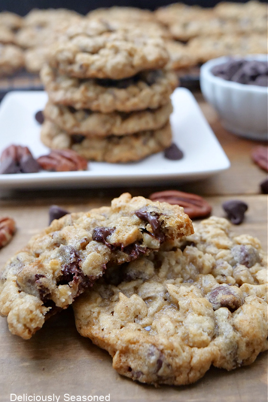 Two cookies stacked up with a plate of cookies in the background.