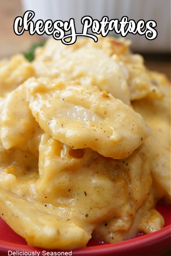 A close up photo of cheesy potatoes with the title of the recipe at the top of the picture.