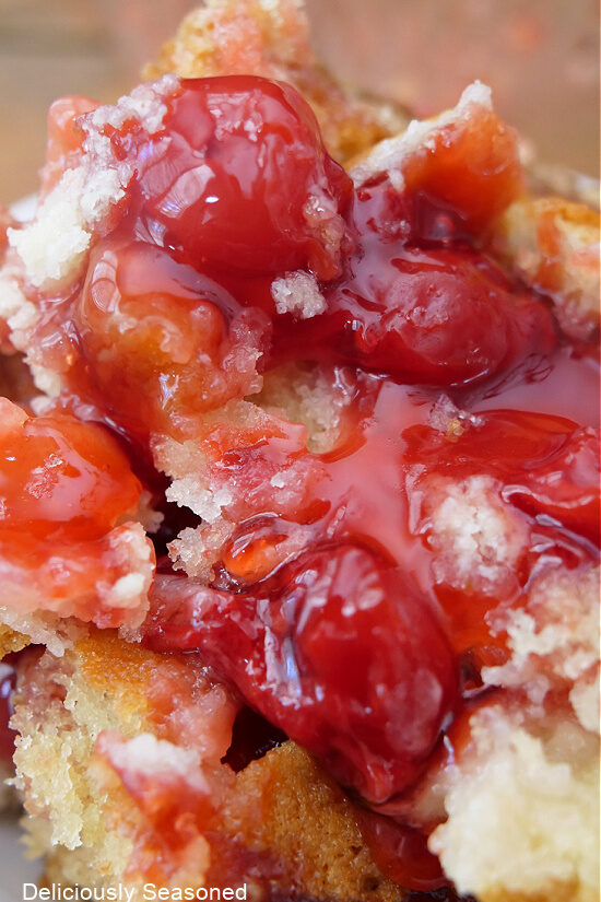 A super close up of a serving of coffee cake with cherries.