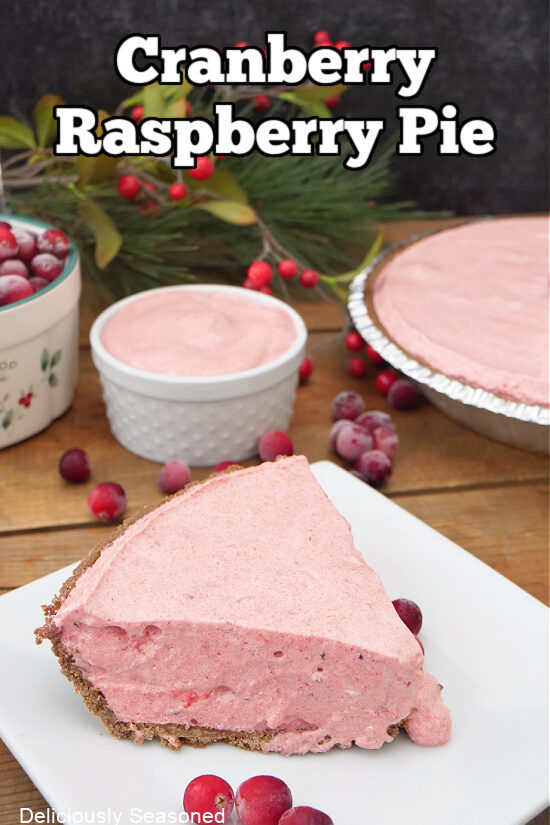 A slice of cranberry raspberry no-bake pie on a square white plate with more pie in the background.