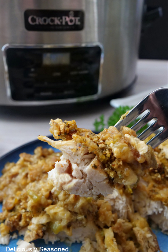 Shredded chicken, topped with stuffing on a fork.
