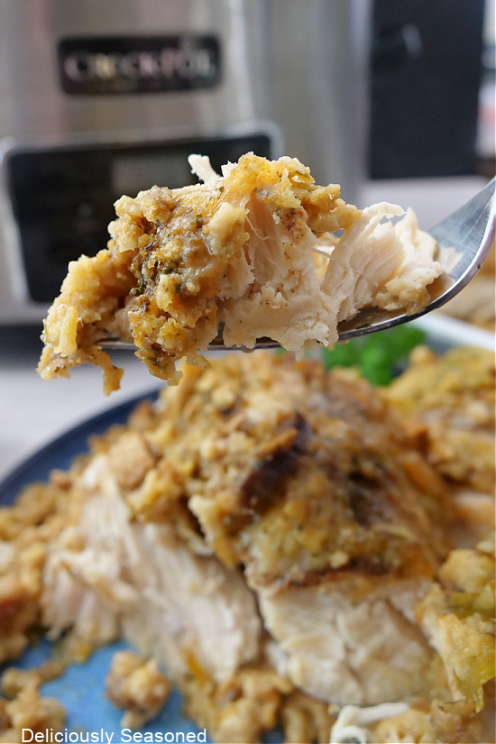 A bite of stuffing and chicken on a fork.