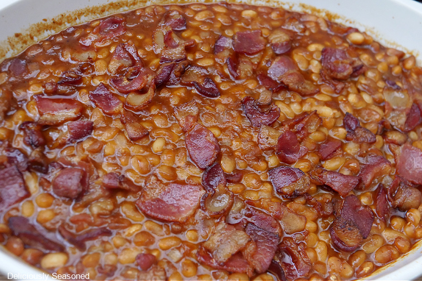 A white baking dish with Boston Baked Beans in it.