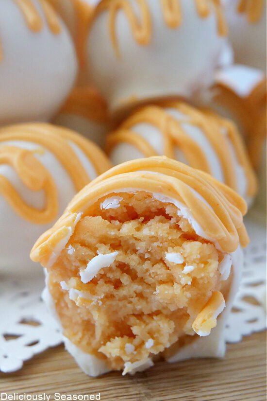 A close up of a bite of an orange flavored cake ball.