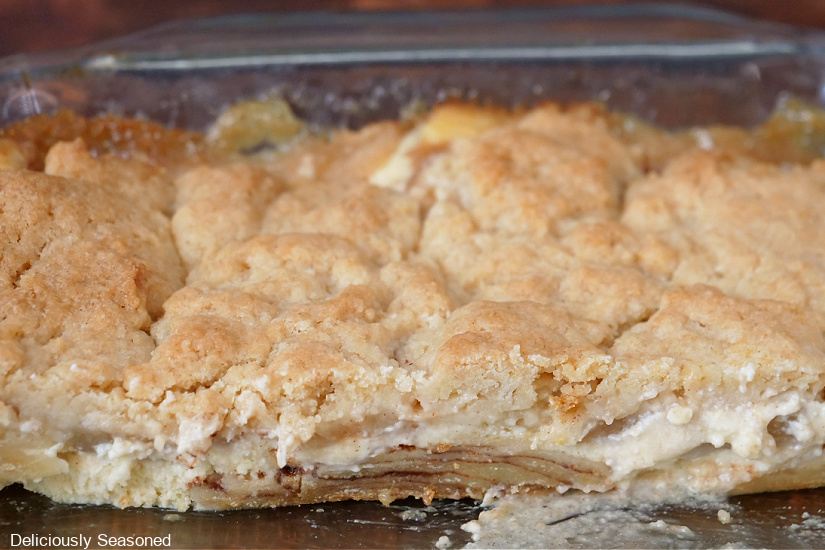 A horizontal photo of pear cobbler in a glass baking dish showing the layers of the cobbler.