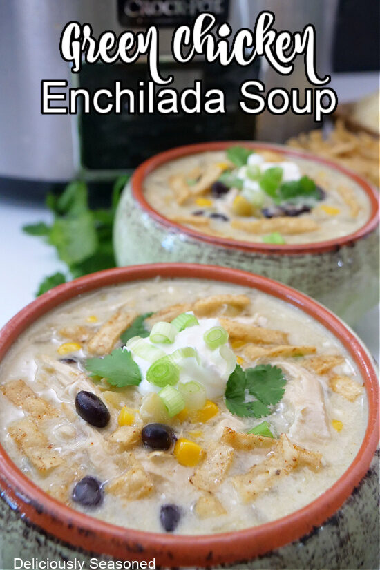 Two green and brown soup bowls filled with chicken enchilada soup.