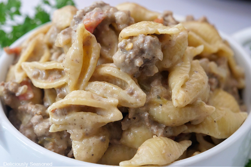 A white bowl filled with ground beef pasta.