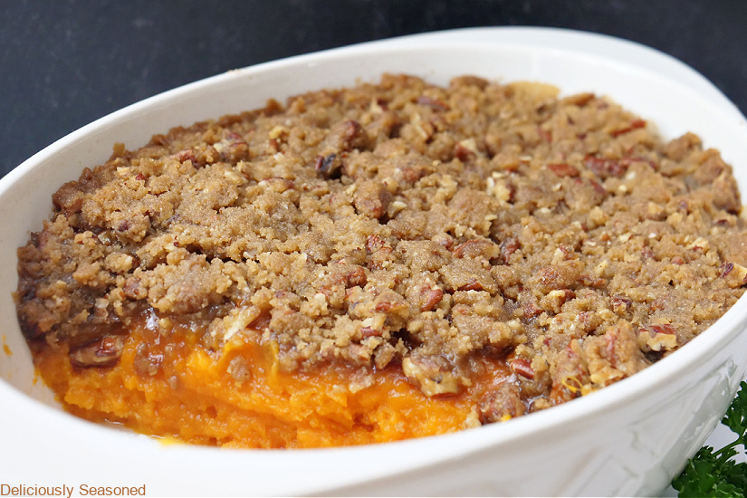 a horizontal photo of a white oval baking dish with sweet potato casserole in it.