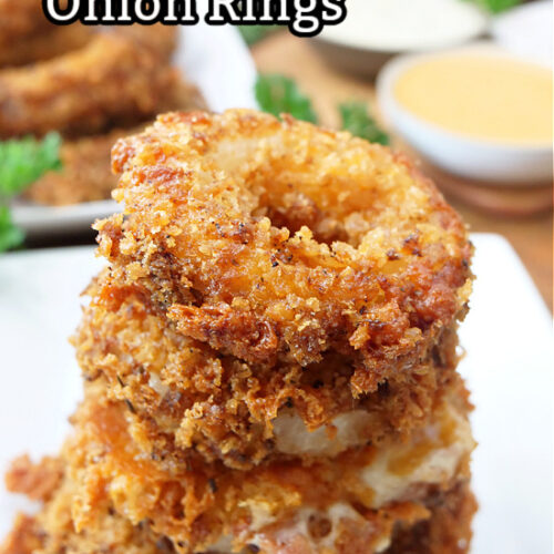 A stack of cheesy onion rings on a white plate.