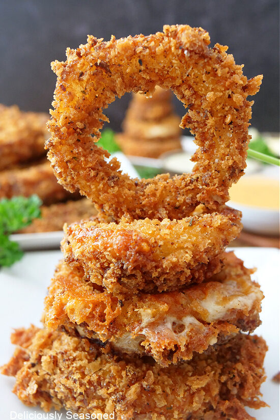 A stack of onion rings on a white plate.