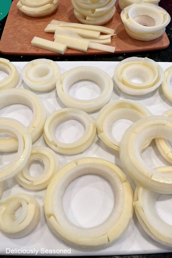 a white surface with a bunch of rings of the onion with cheese in between two rings.