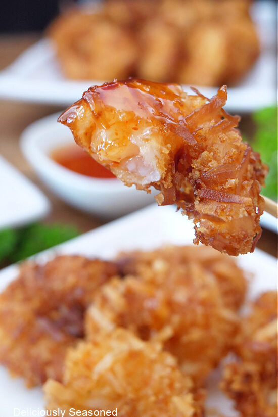 A close up photo of a piece of shrimp with a bite taken out of it.