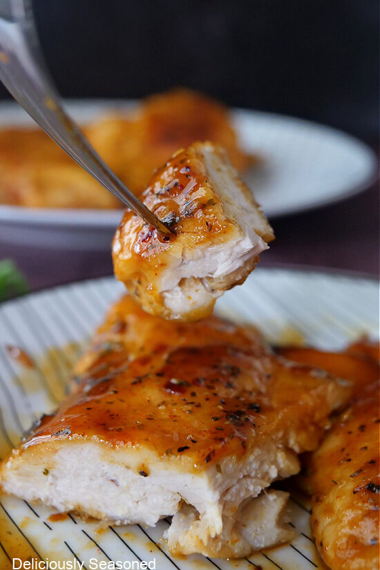 A bite of a piece of chicken breasts on a fork.