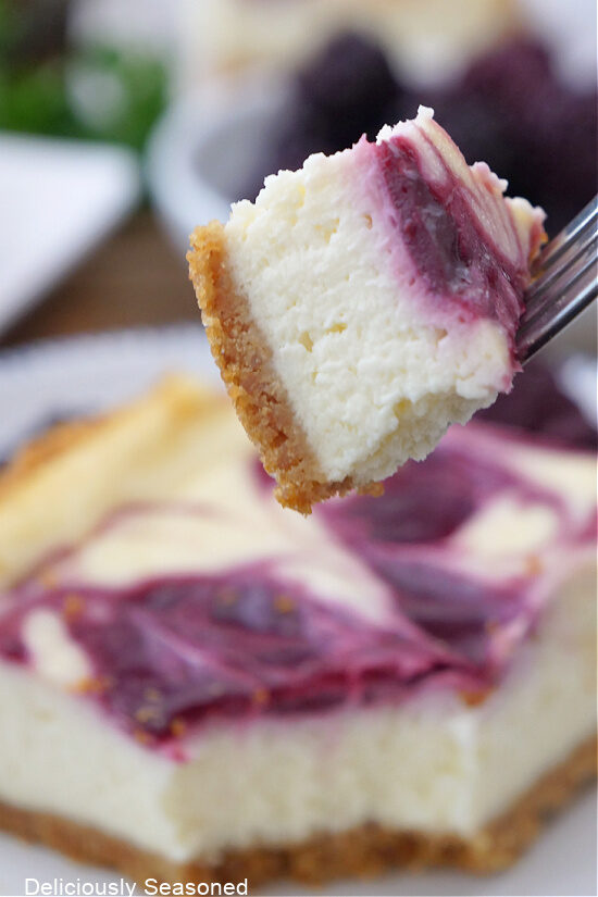 A close up of a bite of cheesecake on a fork.