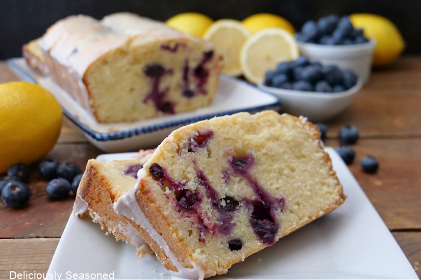 A horizontal photo of slices of blueberry pound cake on a white plate.