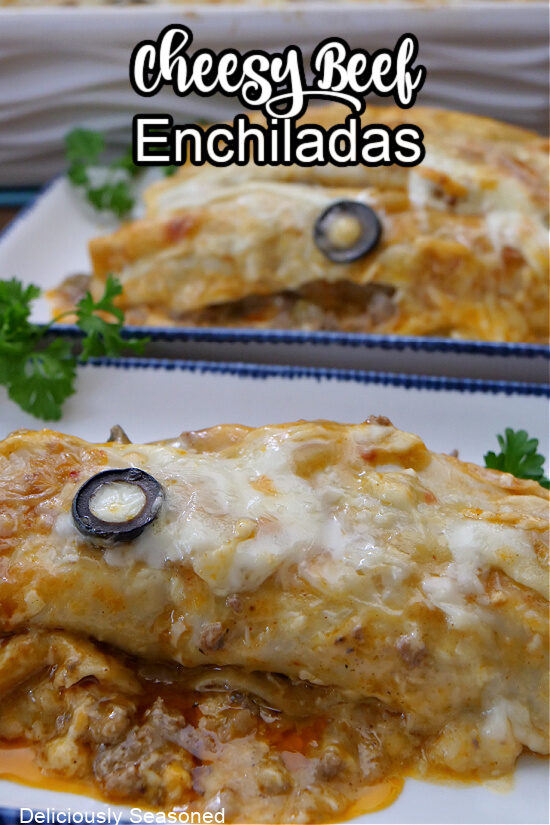 A white oblong plate with blue trim with homemade cheesy beef enchiladas on them.