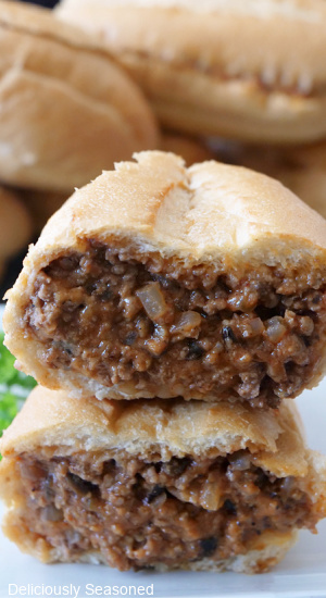 Two halves of a hoagie roll stuffed with ground beef and more stacked on top of each other.