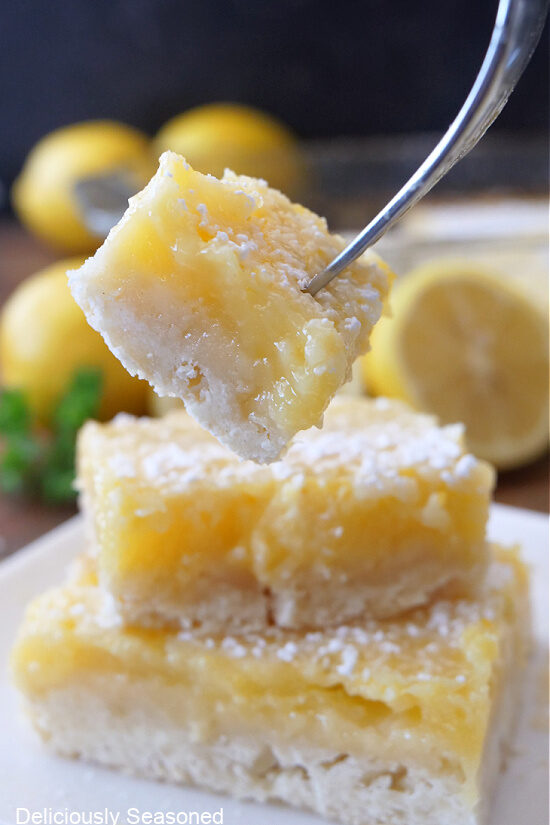 A bite of a lemon square on a fork.
