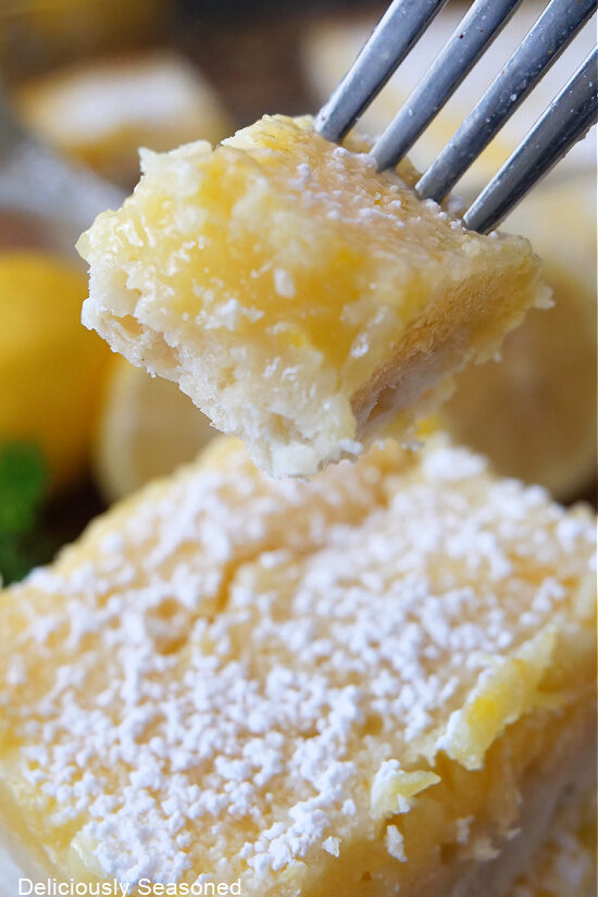 A super close up of a bite of lemon square on a fork.