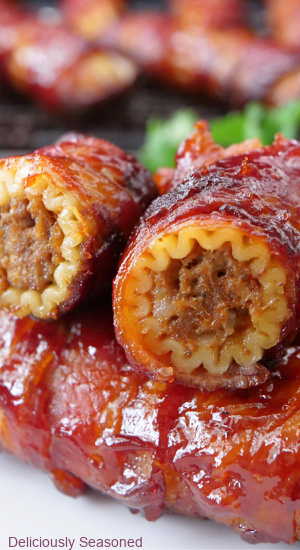 A close up of a couple bacon wrapped shotgun shells recipe showing the meat mixture in the center.