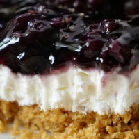 A close up of a slice of blackberry cream cheese dessert.