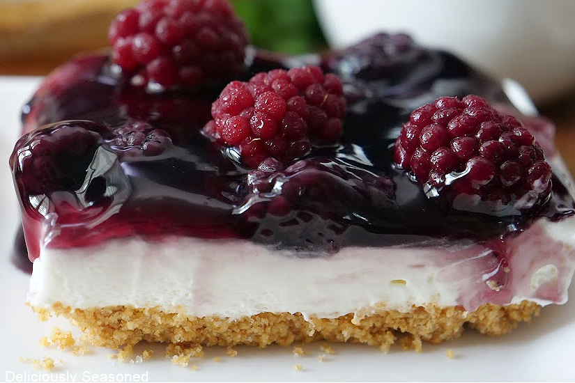 A serving of blackberry cream cheese dessert on a white plate.