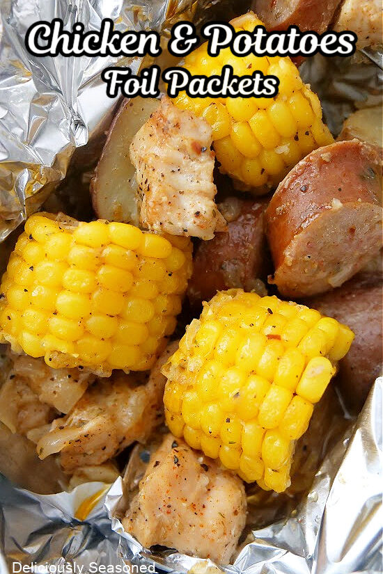 Chicken, sausage, corn and potatoes in foil packets after they were cooked.