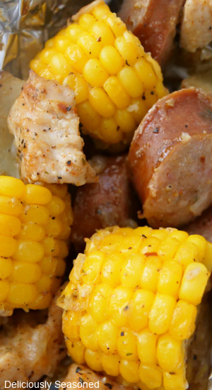 Corn on the cob, chicken pieces, smoked sausage and potatoes in a foil pack.