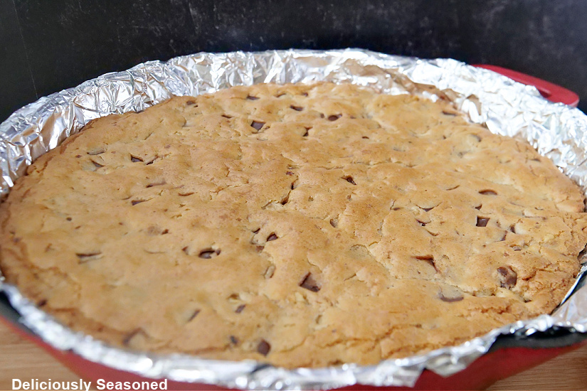 A horizontal photo of a skillet with a chocolate chip cookie pie in it.